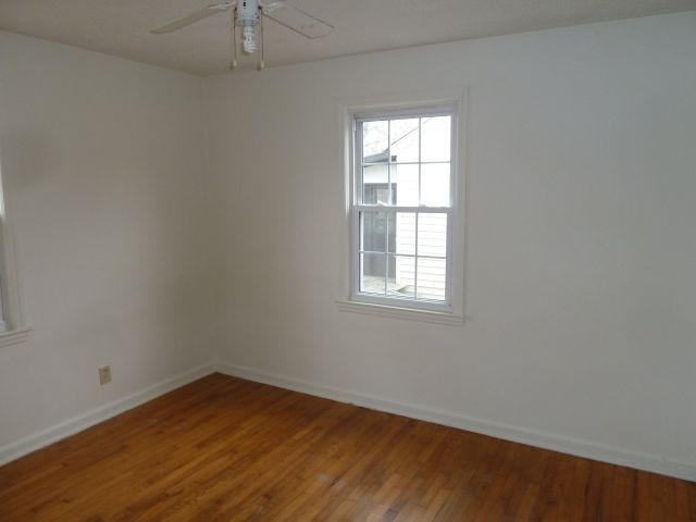 2203 Courtland Road Northeast Roanoke, VA 24012 - Photo 5 of 10 an empty room with wooden floor and windows