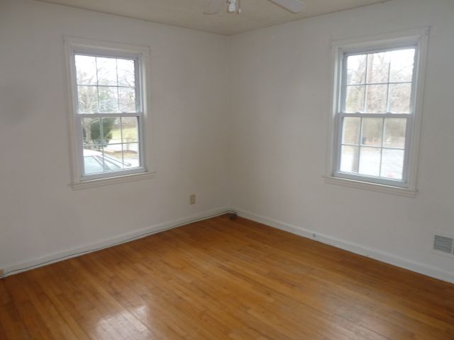 2203 Courtland Road Northeast Roanoke, VA 24012 - Photo 7 of 10 an empty room with wooden floor and windows