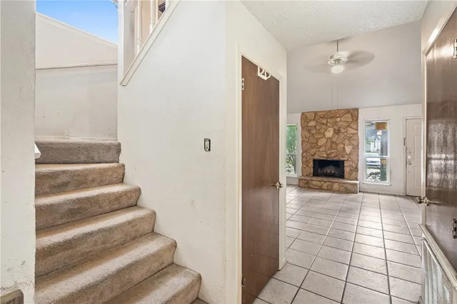 a view of staircase with white walls and a fireplace