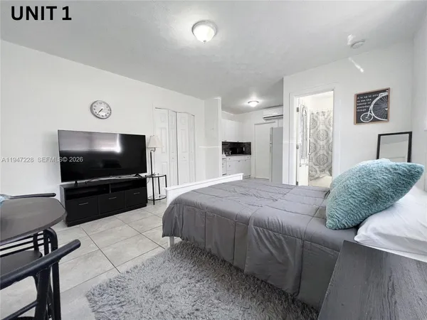 a living room with a bed and a flat screen tv