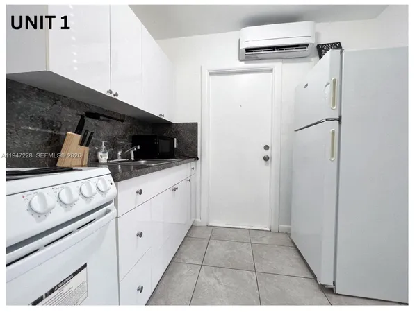 a kitchen with white cabinets and white appliances