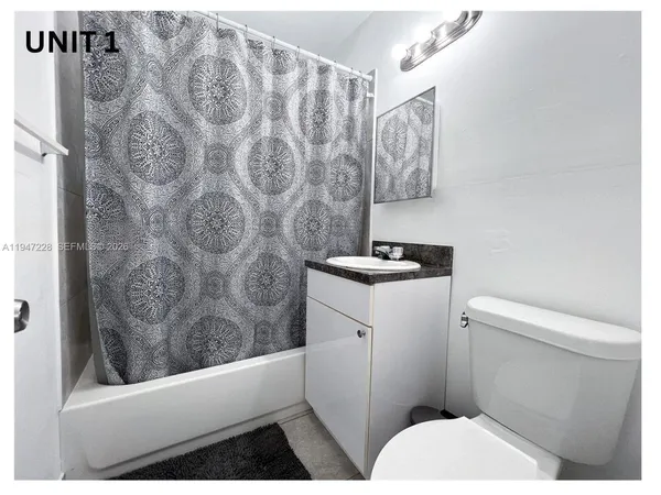 a bathroom with a toilet and a shower curtain