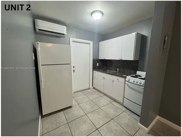 a kitchen with a refrigerator sink stove and cabinets