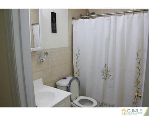 9 Halstead Road New Brunswick, NJ 08901 - Photo 18 of 24 a bathroom with a sink and mirror