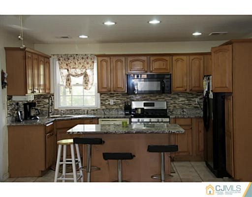 9 Halstead Road New Brunswick, NJ 08901 - Photo 8 of 24 a kitchen with kitchen island granite countertop a sink cabinets and stainless steel appliances