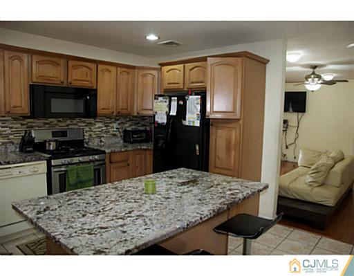 9 Halstead Road New Brunswick, NJ 08901 - Photo 10 of 24 a kitchen with kitchen island granite countertop a refrigerator stove top oven and sink