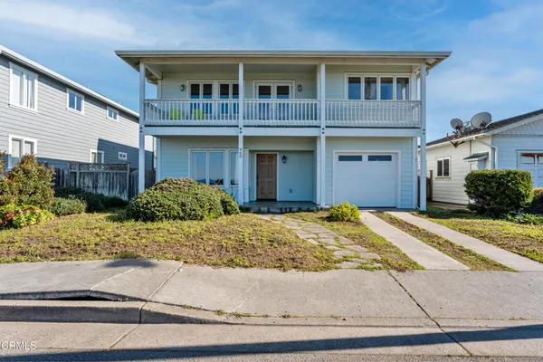 a front view of a house with garage and plants