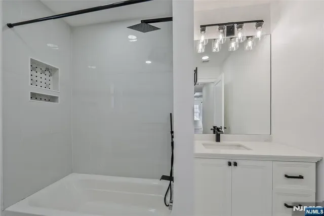 a bathroom with a shower sink and mirror