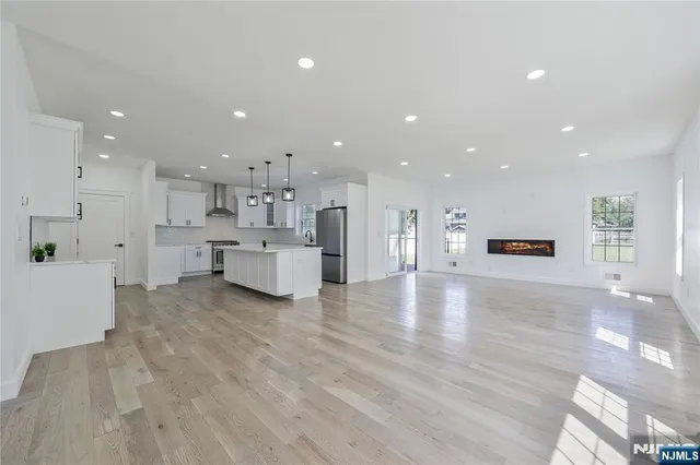 a view of a kitchen with kitchen island white cabinets and wooden floor