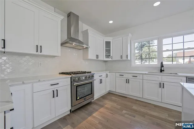 a kitchen with stainless steel appliances white cabinets and a sink