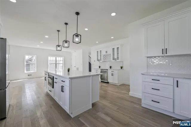 a kitchen with white cabinets and window