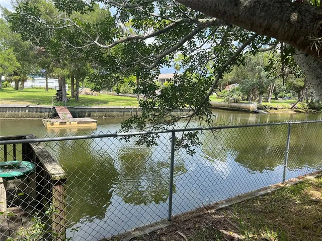 a view of a lake with a yard and potted plants