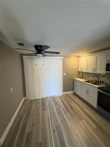 a kitchen with granite countertop a sink cabinets and stainless steel appliances