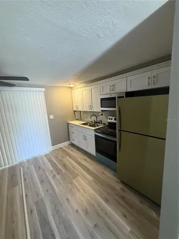 a kitchen with stainless steel appliances a refrigerator and a stove top oven