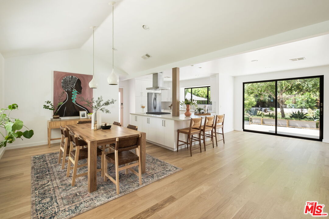 3414 Ferncroft Road Los Angeles, CA 90039 - Photo 7 of 47 a dining room with wooden floor a chandelier a wooden table and chairs
