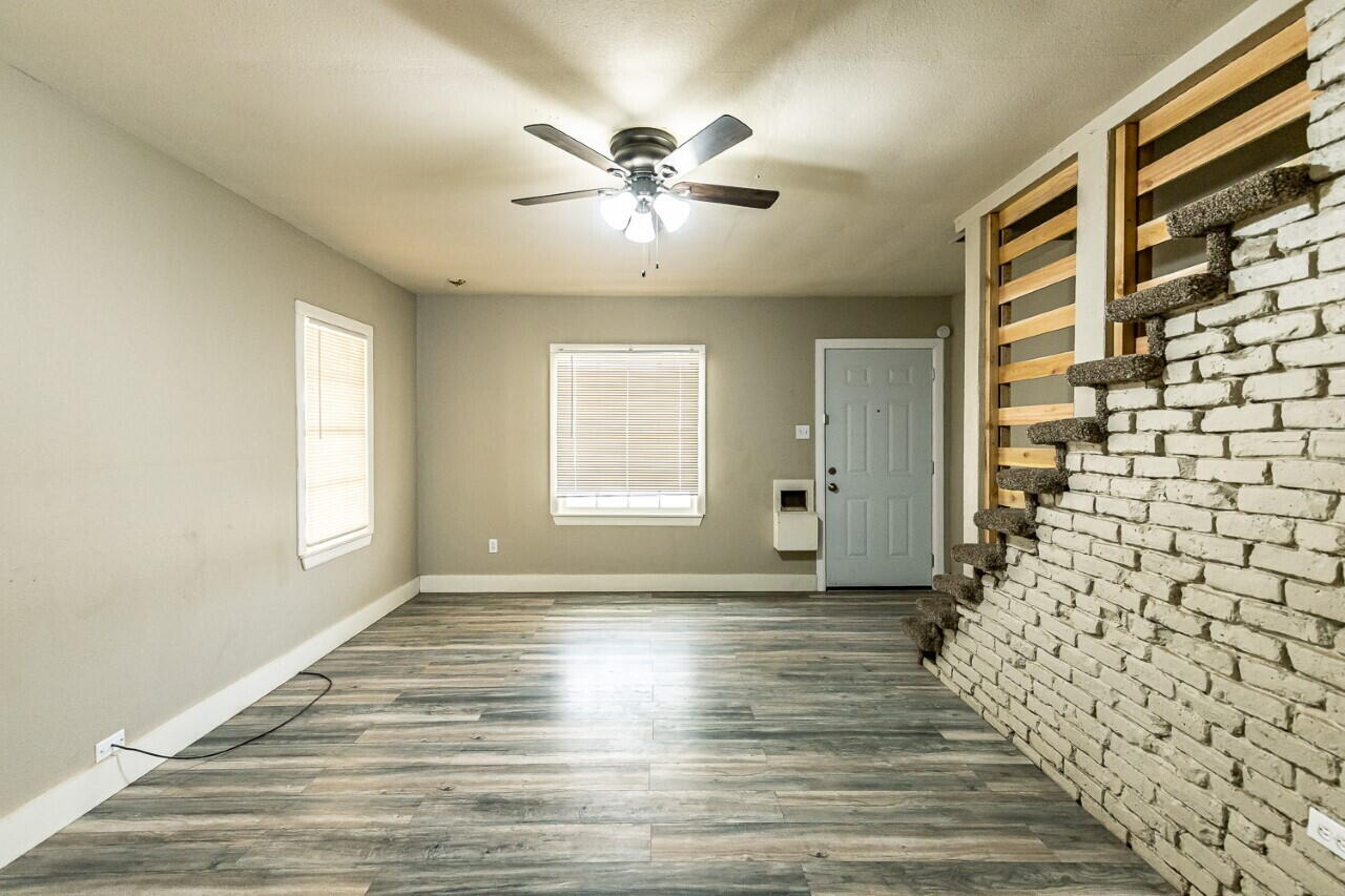 2311 25th Street Lubbock, TX 79411 - Photo 3 of 14 a view of an empty room with a window and a chandelier fan