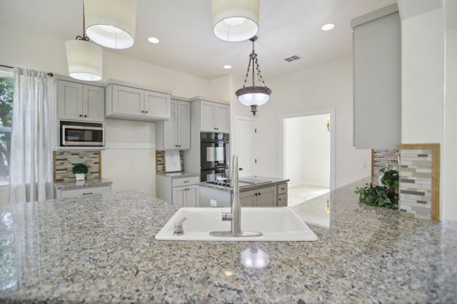 a large kitchen with kitchen island a sink stainless steel appliances and cabinets
