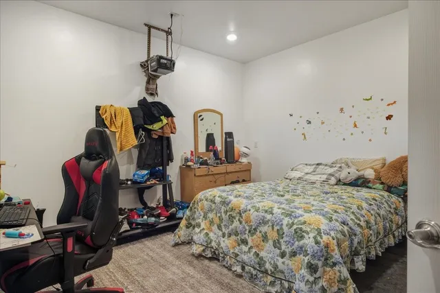 a bedroom with bed a mirror and dresser