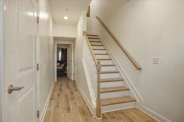 a view of a hallway with wooden floor and entryway