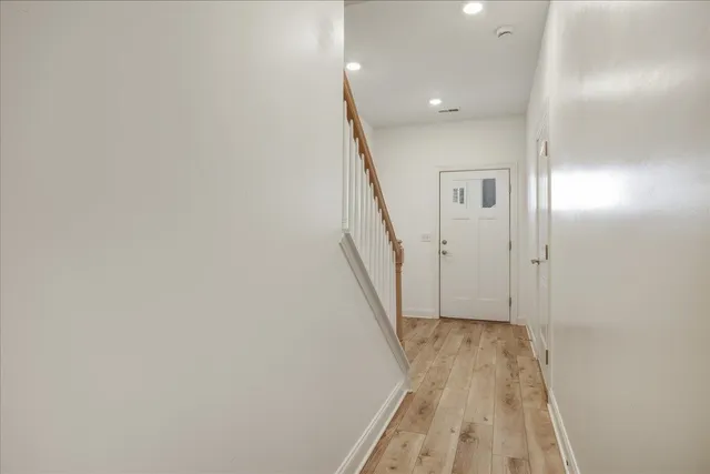 a view of a hallway with wooden floor and staircase