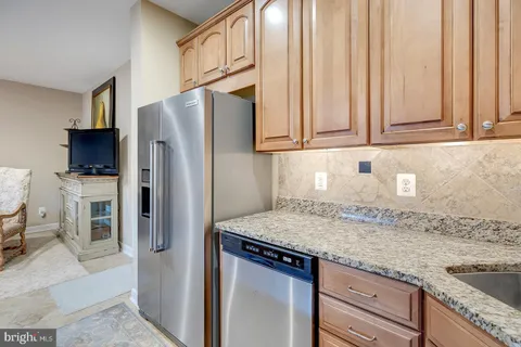 a kitchen with granite countertop a refrigerator and a sink