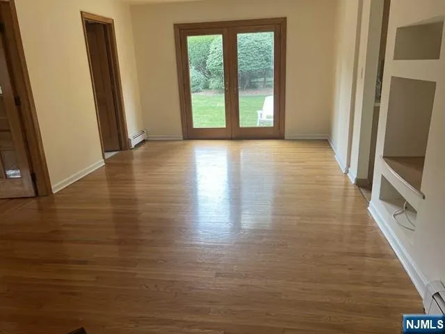 a view of a room with wooden floor and a window