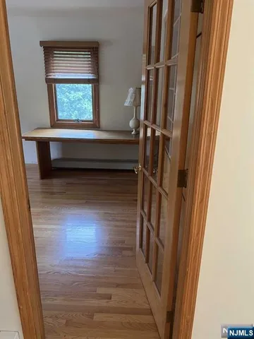 a view of a room with wooden floor and a window