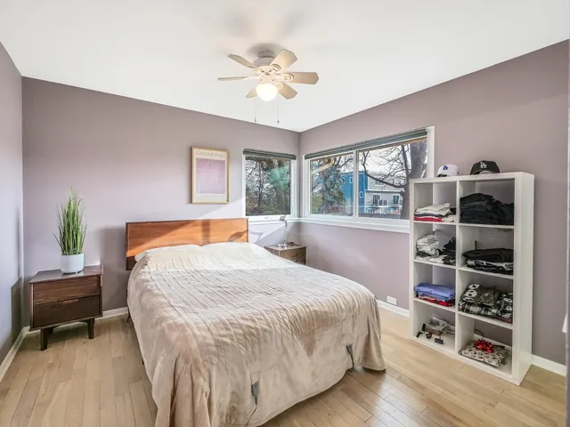 a bedroom with a bed a book shelf and a window