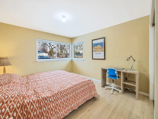 a bedroom with a bed a table and chair