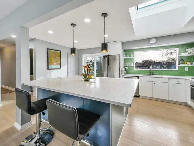 a kitchen with a table chairs sink and cabinets