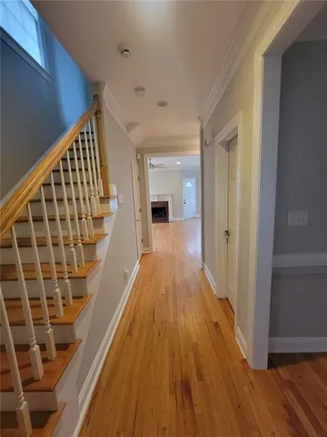 an empty room with wooden floor fireplace and windows