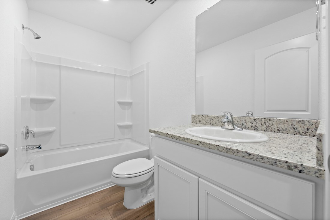 208 Morrison Drive Jarrell, TX 76537 - Photo 7 of 11 a bathroom with a granite countertop sink a toilet and bathtub