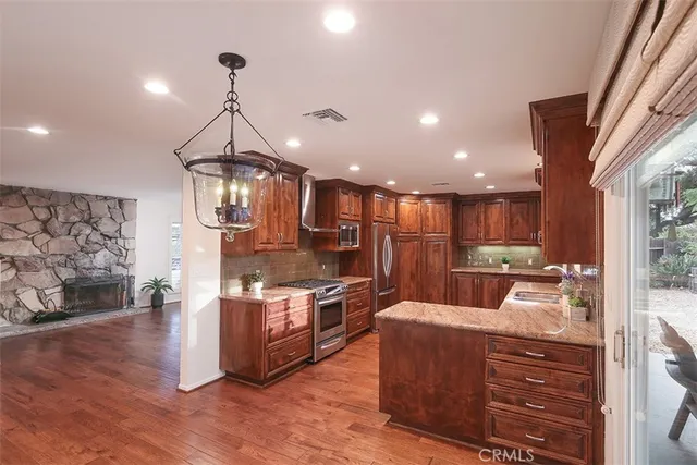 a kitchen with stainless steel appliances kitchen island granite countertop a sink stove and cabinets