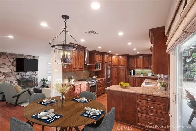 a kitchen with stainless steel appliances granite countertop sink stove refrigerator and cabinets