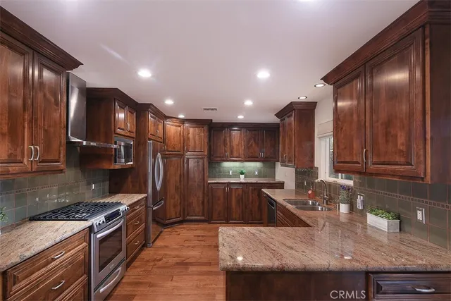 a kitchen with stainless steel appliances granite countertop a sink stove and refrigerator