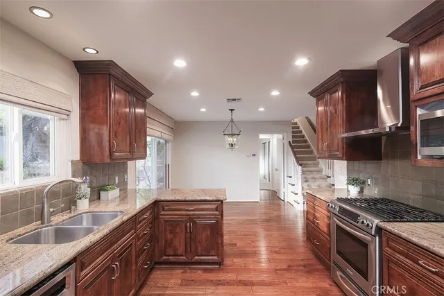 a view of an empty room with wooden floor and stairs