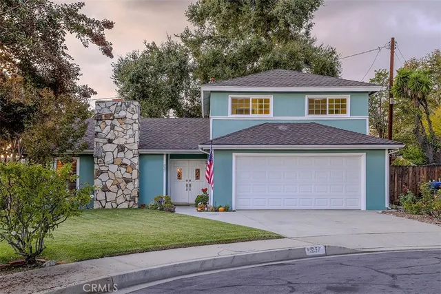 a front view of a house with a garden and garage