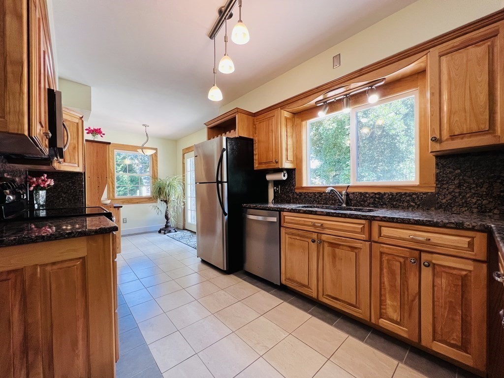 3 Windmill Road Bourne, MA 02532 - Photo 11 of 42 a kitchen with stainless steel appliances granite countertop a refrigerator a sink dishwasher a stove and white countertops with wooden floor