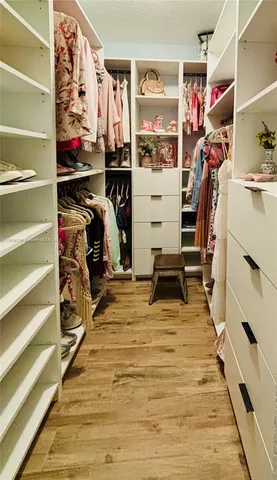 a view of a bedroom with furniture and wooden floor