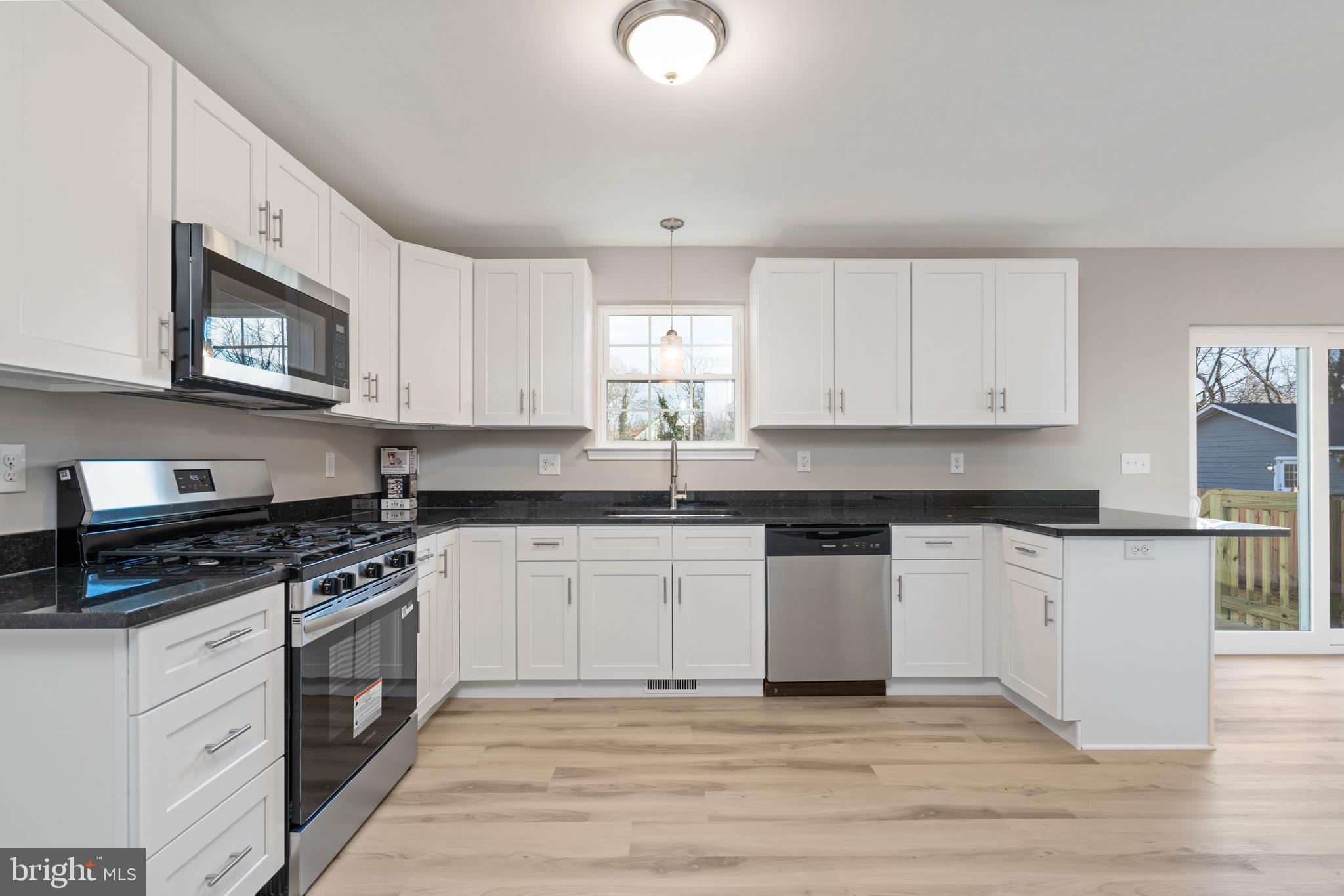 252 Stanger Avenue Glassboro, NJ 08028 - Photo 8 of 27 a kitchen with stainless steel appliances granite countertop a stove a sink and a microwave