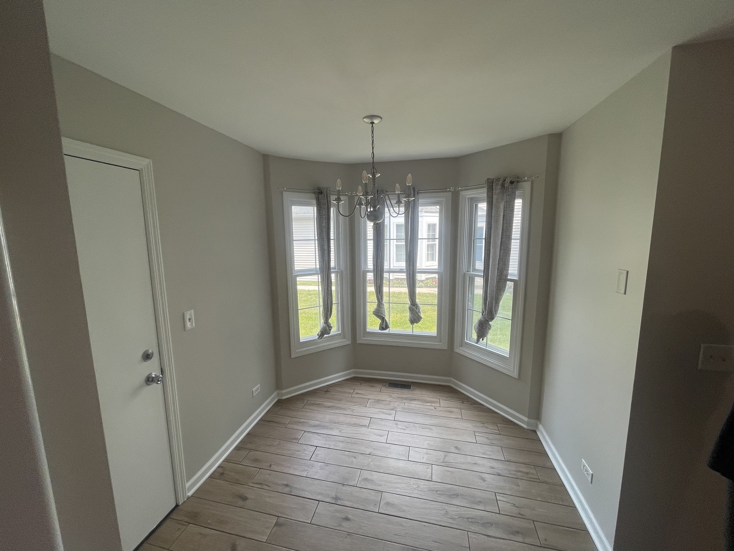 498 Nicole Drive, Unit A Bartlett, IL 60103 - Photo 7 of 7 a view of an empty room with glass door and windows
