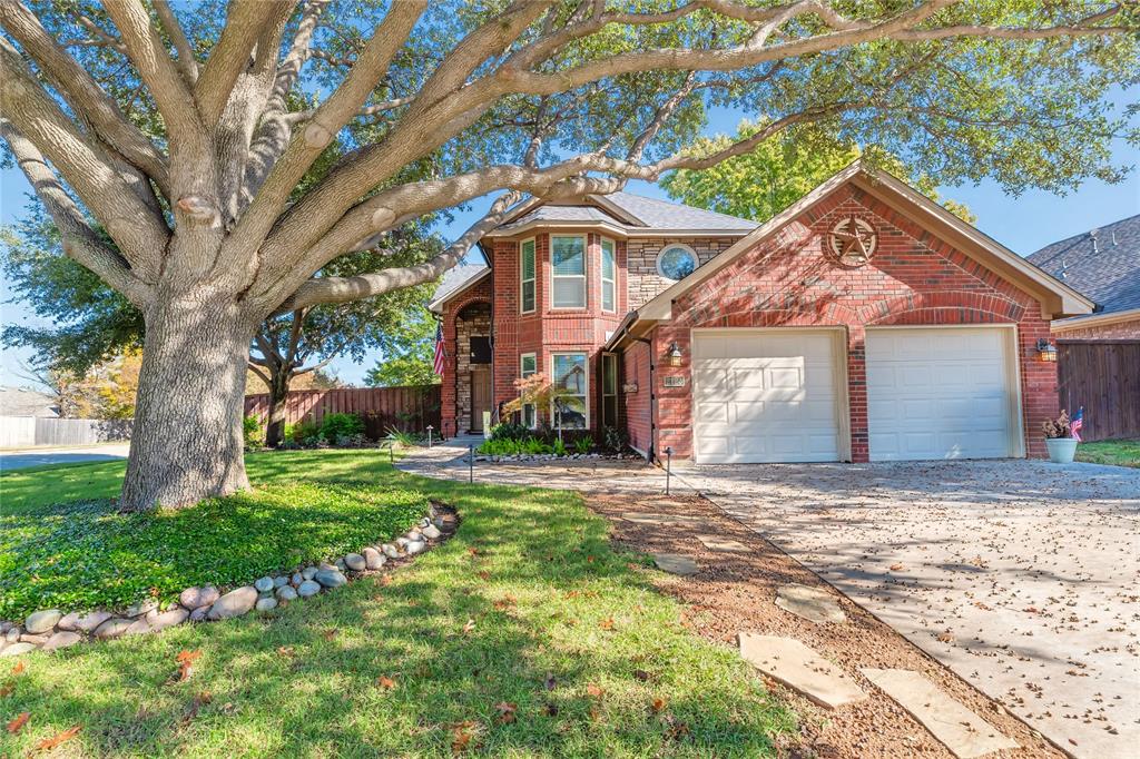 a front view of a house with a yard and an tree