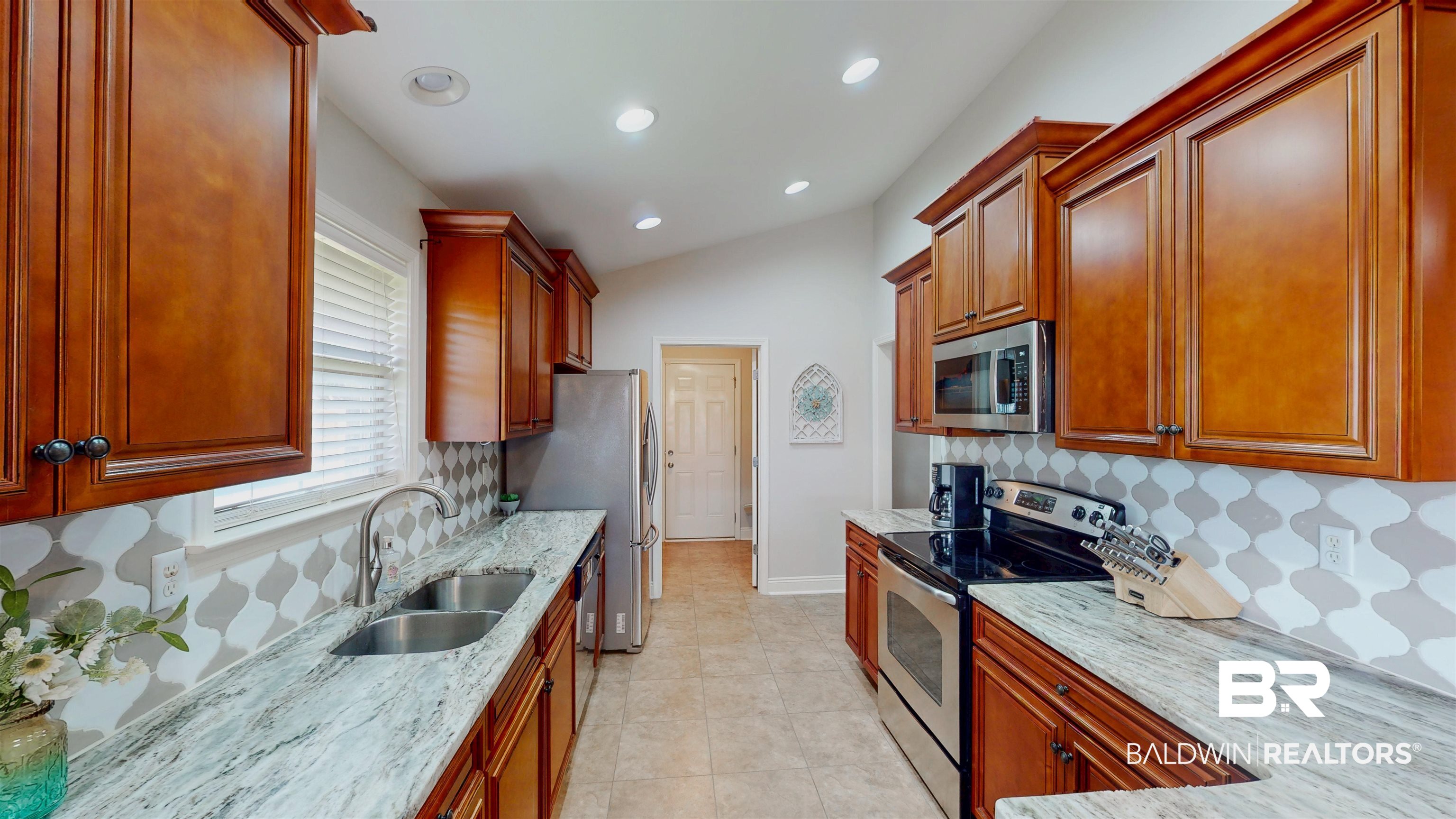 1704 Arcadia Drive Foley, AL 36535 - Photo 15 of 52 Kitchen with appliances with stainless steel finishes, light stone counters, backsplash, recessed lighting, and vaulted ceiling