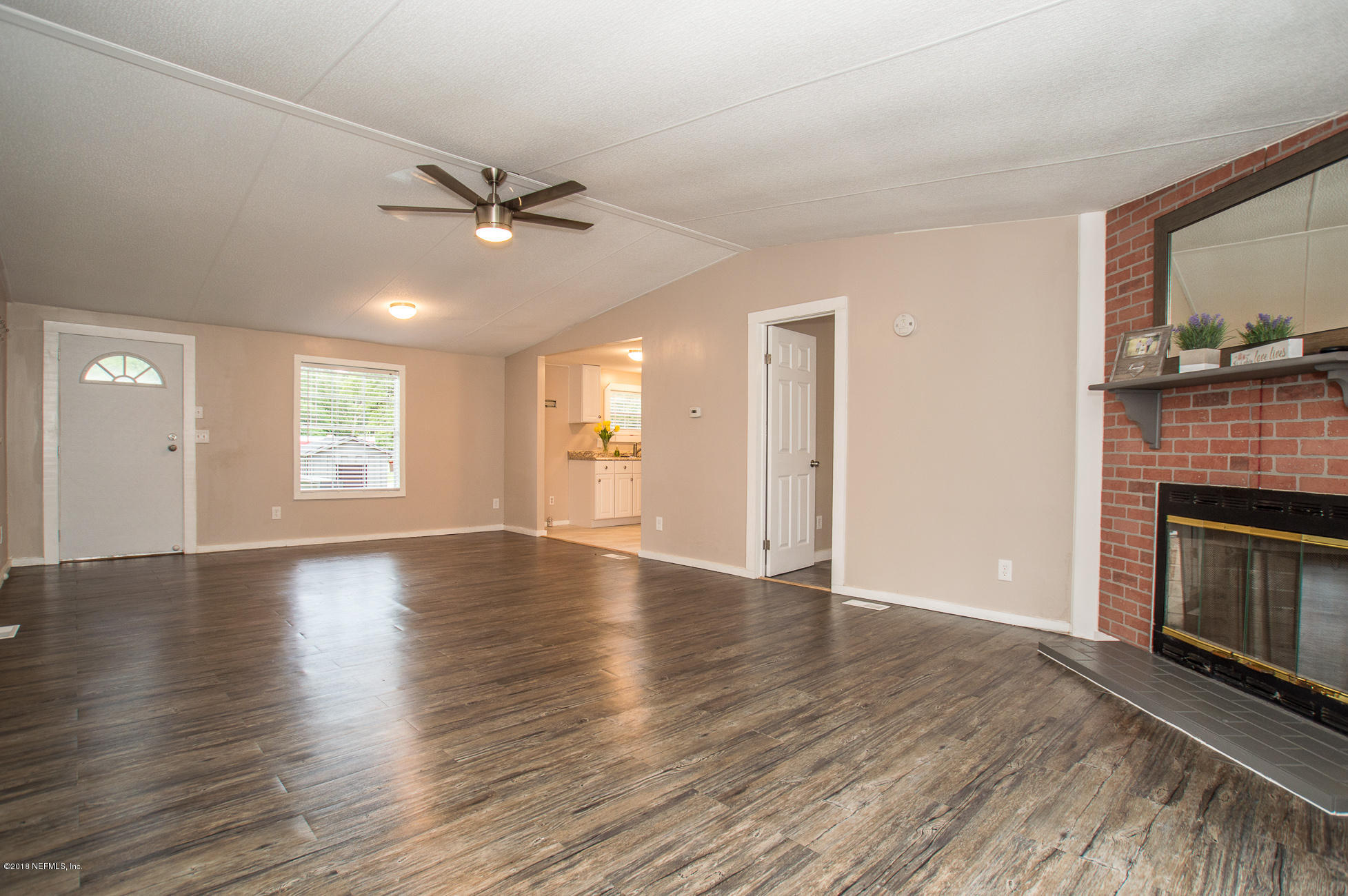 8980 Trail Ridge Road Jacksonville, FL 32234 - Photo 13 of 37 an empty room with wooden floor fireplace and windows