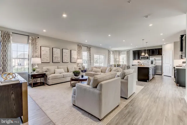 a living room with furniture a large window and a wooden floor