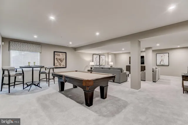 a room with furniture pool table and windows