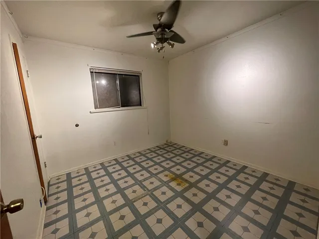 a bedroom with a bed and a chandelier fan