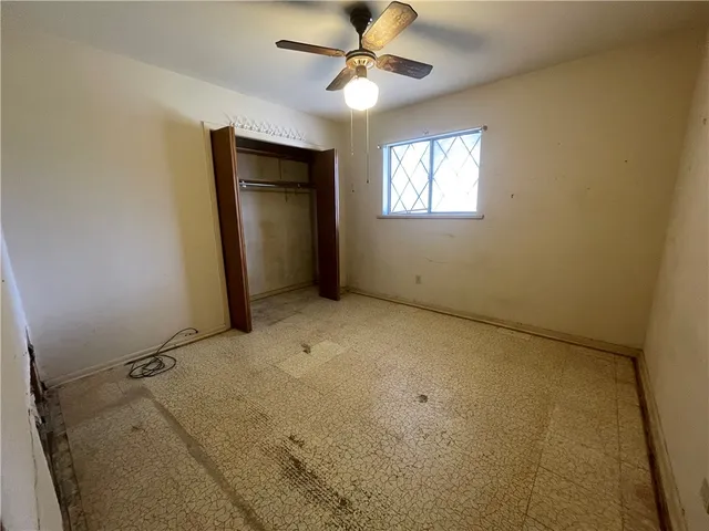 en empty room with windows and a ceiling fan
