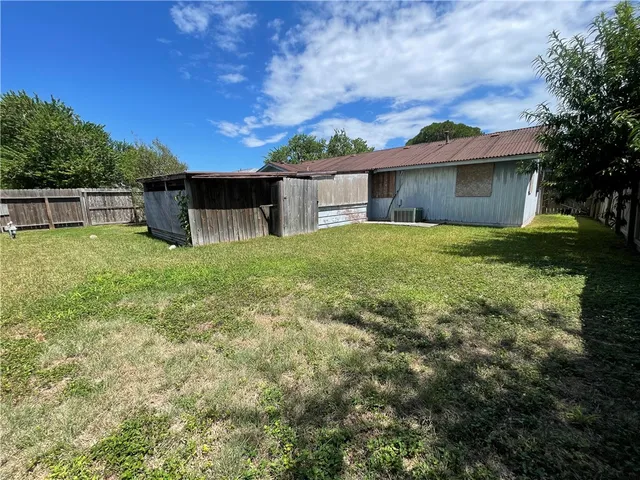 a view of a house with a yard and a large tree