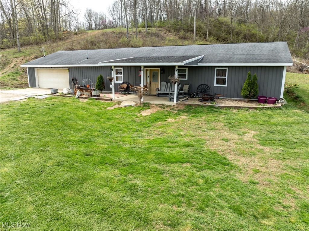 56567 Whiskey Run Road Quaker City, OH 43773 - Photo 38 of 43 View of front of house with a front yard, an attached garage, a patio area, and concrete driveway